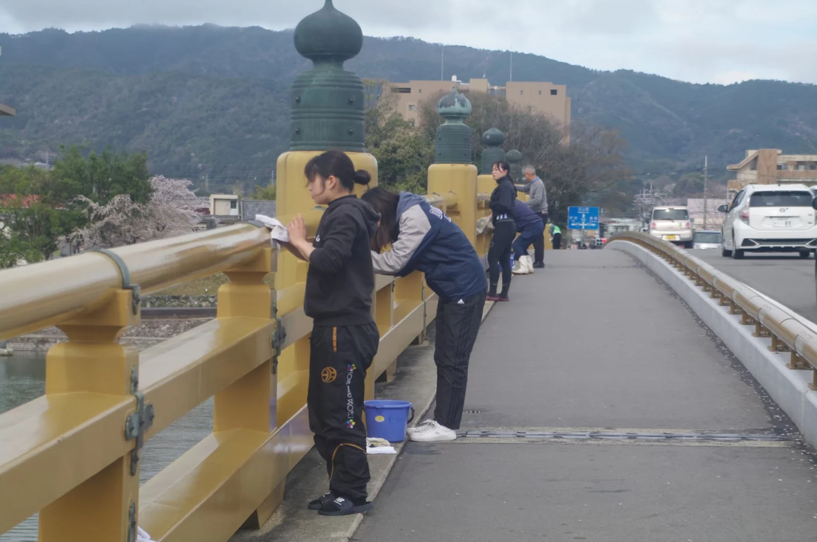 瀬田の唐橋の欄干を拭いて清掃する地域の人たち